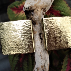 May include: Two square earrings in a gold colour with a hammered finish.