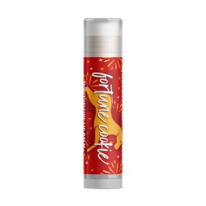 May include: A red lip balm tube with the words "fortune cookie" in white script and a yellow cookie graphic. The tube also has a white cap and a silver base. The words "Moisturizing Lip Balm" are printed vertically.
