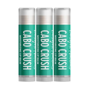May include: Three lip balm tubes with white caps and teal labels. The labels read "CABO CRUSH" in large white letters, with "Daught (vavarats" above and "MOISTURIZING LIP BALM" below. The tubes are cylindrical.