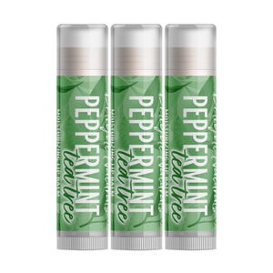 Könnte beinhalten: Drei identische zylindrische Tuben mit feuchtigkeitsspendendem Lippenbalsam Peppermint Tea Tree. Jede Tube hat ein grünes Etikett mit weißem Text Peppermint Tea Tree und Moisturizing Lip Balm, akzentuiert durch ein dezentes Blattmuster.