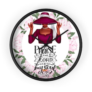 May include: A black and white clock with a floral design and a woman in a burgundy dress and hat. The clock face says "Praise the Lord my soul, Psalm 146:1".