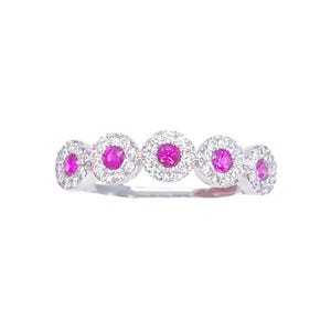 May include: A silver ring with five round pink gemstones surrounded by smaller white gemstones.