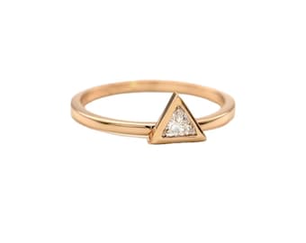 May include: A gold ring with a triangular shaped setting featuring a small, clear diamond.