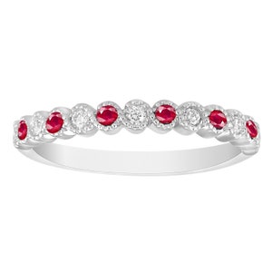 May include: A delicate white gold band ring with alternating red rubies and small diamonds. The ring has a vintage-inspired design with a scalloped edge.