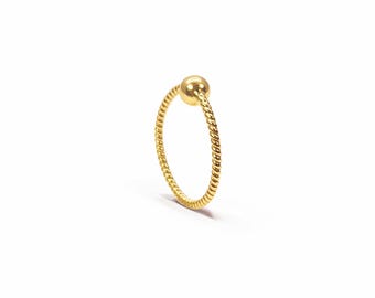 May include: A gold-colored hoop ring featuring a twisted rope-like texture along the band and a single smooth, spherical ball bead attached at the top. The circular jewelry piece is presented in a vertical orientation against a plain background.