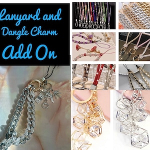 May include: A collection of lanyards and dangle charms featuring various designs including rhinestone-encrusted chains, metallic link chains, and geometric crystal pendants. The text "lanyard and Dangle Charm Add On" is displayed in blue.