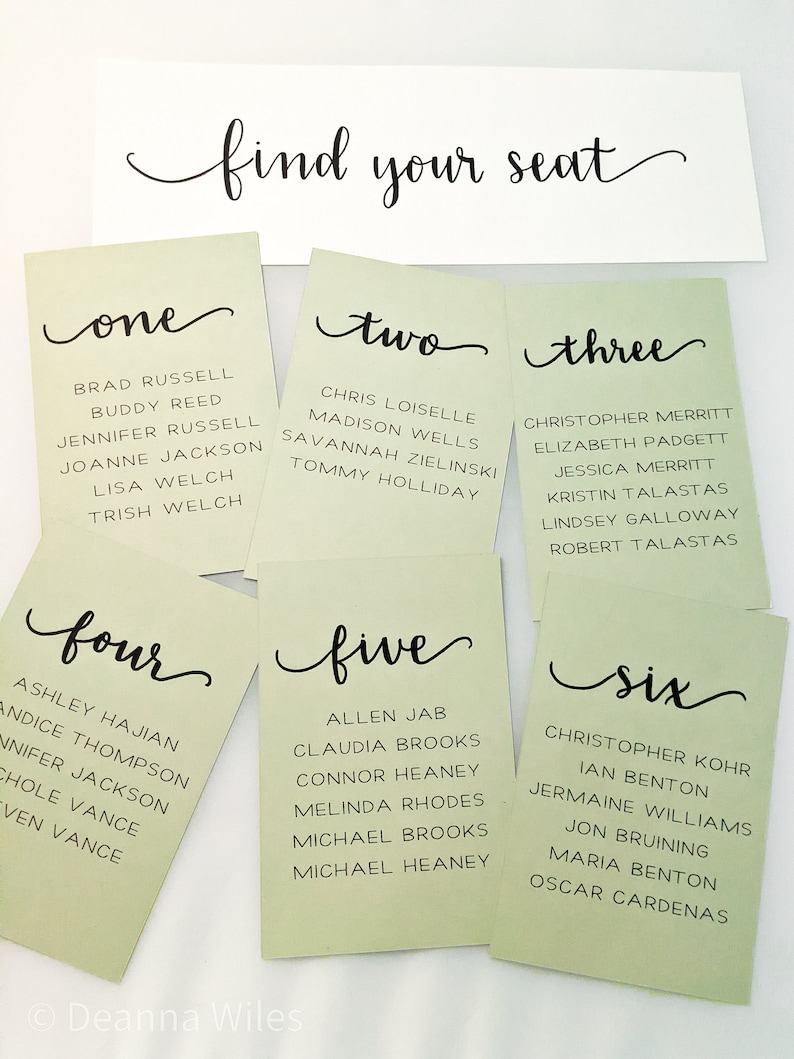 May include: Six green cards with white text and black calligraphy. Each card has a number from one to six and a list of names. The cards are arranged in two rows of three. The top card reads "find your seat".