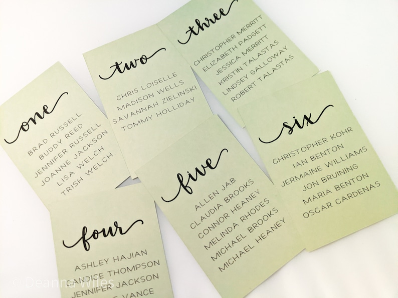 May include: Six green cards with handwritten numbers one through six and a list of names on each card. The cards are arranged in a staggered pattern.