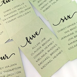 May include: Green table cards with black calligraphy numbers and names. The numbers are 'four', 'five', and 'six'.