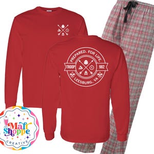 May include: Red long-sleeve shirt with a white graphic of a compass, tent, and campfire with the text "Prepared. For Life. Troop 982 Leesburg, VA". Red and gray plaid pajama pants.