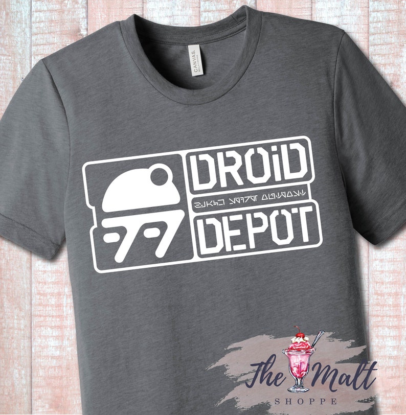 May include: Gray t-shirt with a white graphic design of a droid head and the text "DROID DEPOT" with a stylized font.