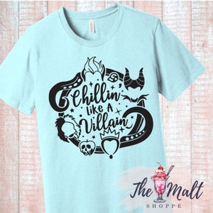 May include: Light blue t-shirt with a black graphic design featuring a circle with various Disney villain icons and the text "Chillin' like a Villain".