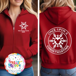 May include: A red zip-up hoodie with white snowflake and Mickey Mouse designs. The front features "Walt Disney World 2025". The back has a circular design with "Once Upon a Christmastime". A festive apparel item.