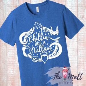 May include: A royal blue t-shirt with a white graphic design featuring a circle of Disney villain icons and the text "Chillin' Like A Villain".