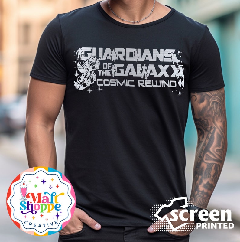 Może przedstawiać: Czarny T-shirt z białym nadrukiem graficznym postaci Strażnik&oacute;w Galaktyki i tekstem "Guardians of the Galaxy Cosmic Rewind".