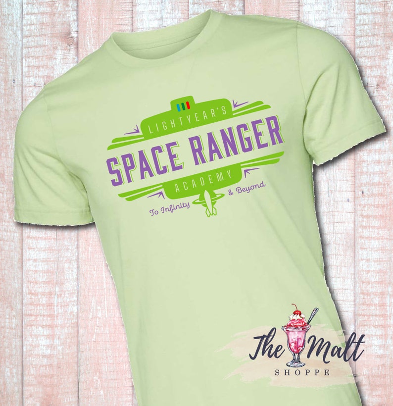 May include: A light green t-shirt with a green and purple logo that says "Lightyear's Space Ranger Academy To Infinity & Beyond".