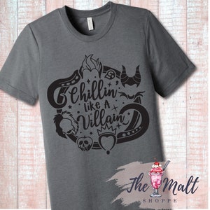 May include: A dark gray t-shirt with a black graphic design featuring the text "Chillin' Like A Villain" surrounded by various Disney villain icons.