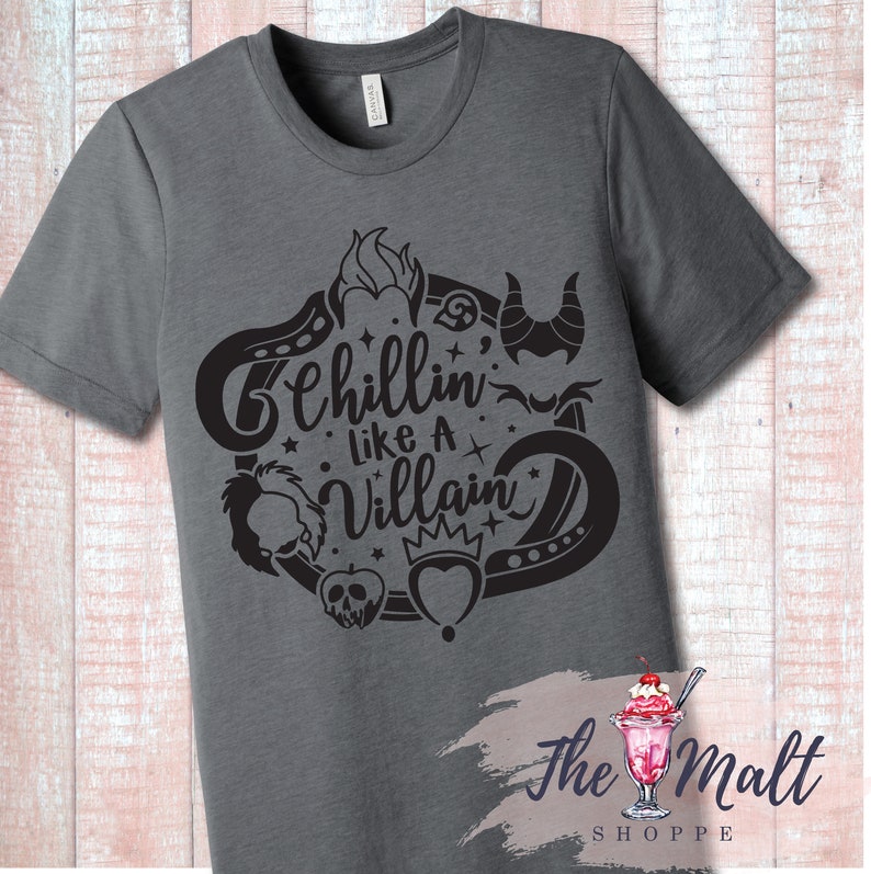 May include: A dark gray t-shirt with a black graphic design featuring the text "Chillin' Like A Villain" surrounded by various Disney villain icons.