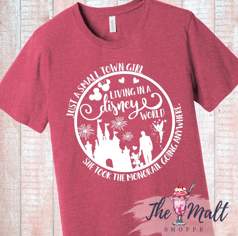May include: Red t-shirt with a white graphic design of a castle, fireworks, and the text "Just a small town girl living in a disney world she took the monorail going anywhere."