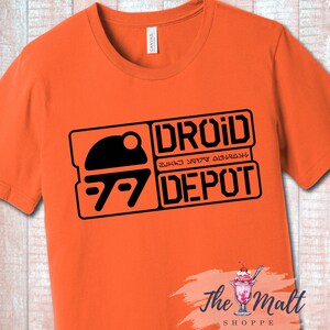 May include: Orange t-shirt with a black graphic of a droid head and the text "DROID DEPOT" in a rectangular box.