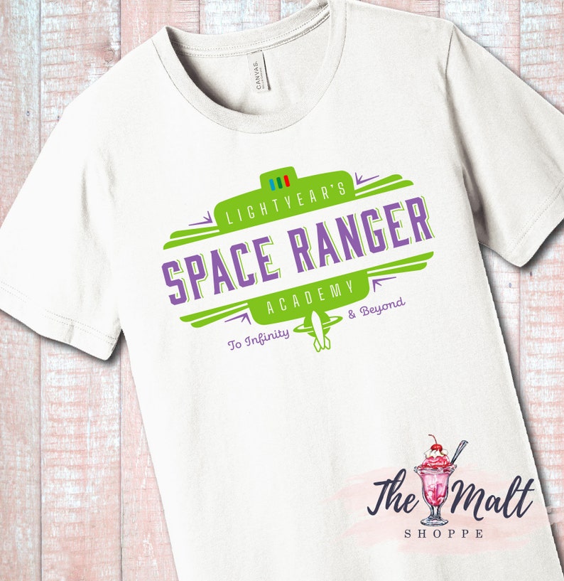 May include: White t-shirt with a green and purple logo that says "Lightyear's Space Ranger Academy To Infinity & Beyond".