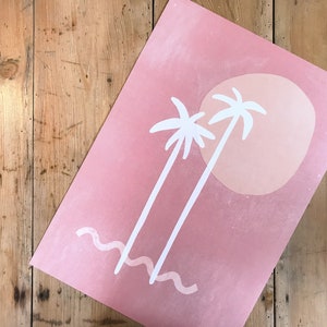 May include: A pink and white print with two palm trees and a large sun. The background is a light pink with a gradient to a darker pink at the top.