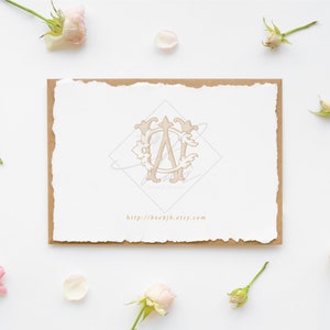May include: A white card with a torn edge, featuring a monogram design in a diamond shape. The card is set on a brown backing and surrounded by pink roses and petals. The website address http://bee9jb.etsy.com is printed on the card.