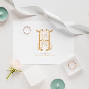 May include: A white card with a gold ornate letter H monogram design. The card is surrounded by white ribbon, a small white box, and a rose.