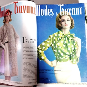 Peut inclure: Une couverture de magazine vintage mettant en scène deux femmes à la mode. Le magazine s'intitule "Modes & Travaux" et la couverture présente une femme en blouse verte et blanche à pois et une jupe blanche. L'autre femme porte un manteau gris et une écharpe violette. La couverture du magazine présente également le texte "Tricotez Weed!" et "Edition Modes et Travaux".