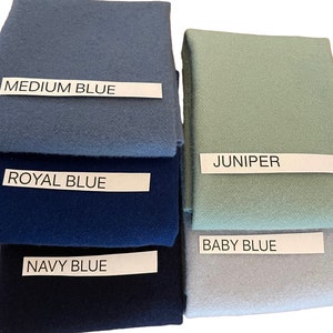 May include: A collection of fabric swatches in various shades of blue and green. The swatches are labeled with the following colors: Medium Blue, Royal Blue, Navy Blue, Juniper, and Baby Blue. The fabric appears to be a soft, textured material.
