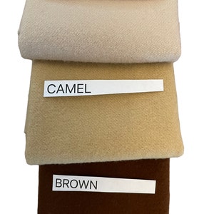 May include: Three fabric swatches in beige, camel, and brown. Each swatch has a label with its color name. The beige swatch is at the top, followed by camel, and brown at the bottom. The fabrics appear to be a soft, woven material.