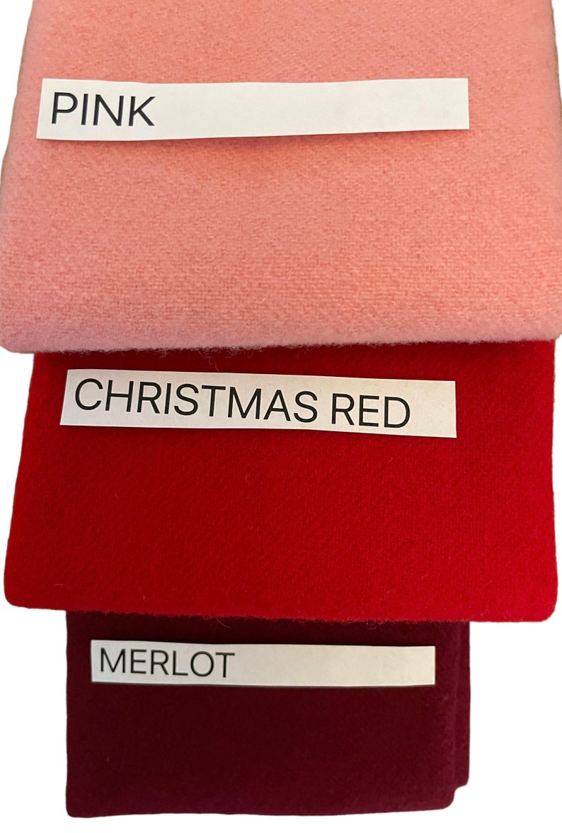 May include: Three fabric swatches in pink, Christmas red, and merlot. Each swatch has a label with the color name printed in black. The pink swatch is at the top, followed by the red and merlot swatches.