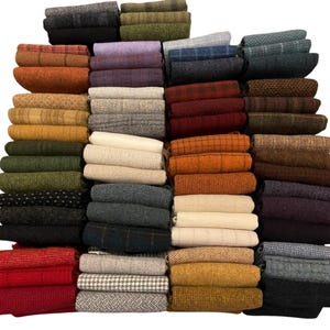 May include: A collection of folded fabric swatches in various colors and patterns. The swatches include shades of red, orange, yellow, green, blue, and gray. Patterns include plaid, herringbone, and solid colors. The fabrics appear to be wool or a similar material.