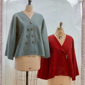 May include: A sewing pattern envelope for a Simple Swing Jacket by Indygo Junction. The cover displays two jackets on dress forms: a blue double-breasted jacket with buttons and pockets, and a red jacket with a single toggle closure.