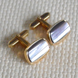 May include: A pair of gold cufflinks with a rectangular mother-of-pearl inlay.