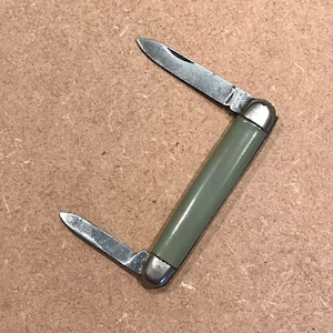 May include: A small, green handled pocket knife with two blades. The knife has a silver metal handle and the blades are made of stainless steel.
