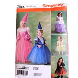 May include: Simplicity sewing pattern number 2569 for making children's costumes. The pattern includes instructions for making four different costumes: a pink princess, a blue princess, a yellow princess, and a witch. The pattern is for sizes AA, 1, 2, and 3.