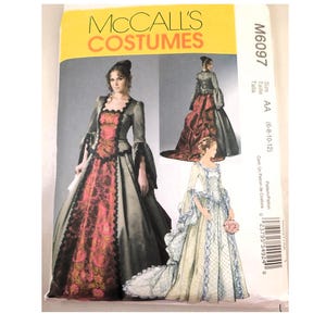 May include: A McCall's Costumes sewing pattern featuring three different historical gowns. The pattern cover has a yellow banner with the text "McCall's Costumes". The gowns are in shades of black, red, and cream.