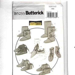May include: A Butterick B5233 sewing pattern envelope featuring illustrations of seven different styles of historical footwear, including boots and moccasins with various lacing, fringe, and buckle details, labeled A through G on a white background.