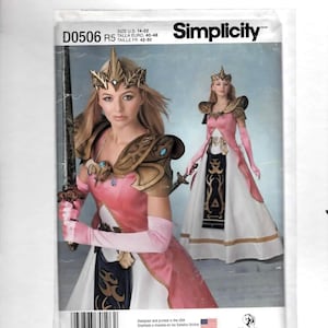 May include: Simplicity sewing pattern D0506 R5 featuring a woman in a pink and white fantasy dress with gold accents, a crown, and a sword. The pattern includes sizes 14-22. The package has the Simplicity logo.