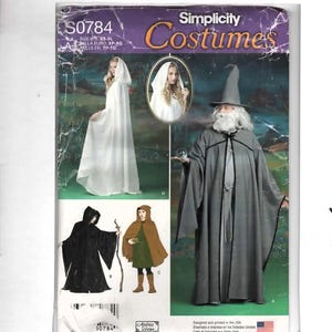 May include: A Simplicity Costumes sewing pattern envelope S0784 for hooded cloaks and robes. The cover features illustrations of a white hooded cloak, a black hooded cloak, a brown cape, and a grey wizard robe with a pointed hat and white beard.