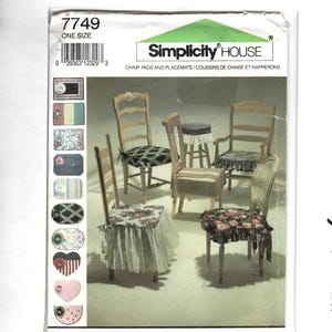 May include: A Simplicity House 7749 sewing pattern envelope for chair pads and placemats. The cover features illustrations of various chairs decorated with fabric cushions, ruffles, and fringe, along with a column of small fabric swatches.