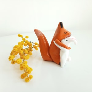 “A hug” figurine. Fox and rabbit figurine entwined.