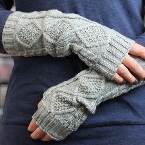 May include: A pair of gray knitted fingerless gloves with a diamond pattern. The gloves are worn on a person's hands.