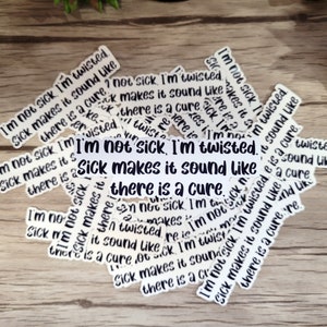 May include: A collection of white stickers with black text that reads "I'm not sick I'm twisted. Sick makes it sound like there is a cure."