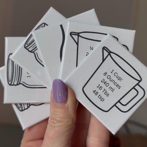 May include: A set of three ceramic mugs with a speckled, matte finish. The mugs are in shades of cream, light gray, and dark gray. Each mug has a simple, minimalist design, perfect for coffee or tea.