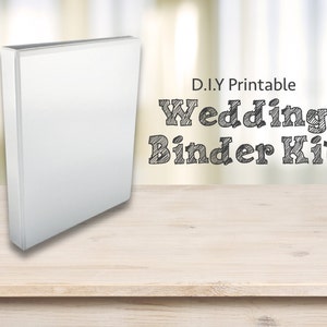 May include: A white binder on a wooden table with the text "D.I.Y Printable Wedding Binder Kit" in black.