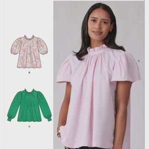 May include: Simplicity S3271 sewing pattern envelope featuring a light pink blouse with a ruffled mock neck and short sleeves. Illustrations show a patterned short-sleeve blouse and a solid green long-sleeve blouse with gathered cuffs.