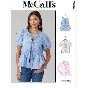 May include: McCall's sewing pattern M8557 for a blouse with a tie front. The pattern includes four different styles: a sleeveless blouse, a short-sleeved blouse, a long-sleeved blouse, and a blouse with a ruffled hem.
