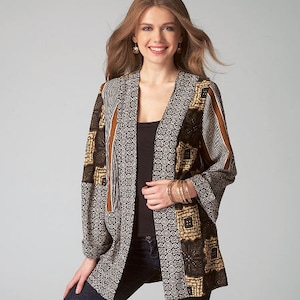 May include: A long-sleeved, black and white patterned cardigan with brown accents. The cardigan has a relaxed fit and a wide, open neckline.
